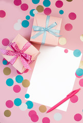 Decorated boxes, confetti and blank white sheet of paper.