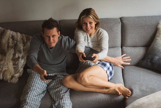 Couple playing video games in living room
