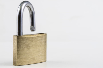 Fototapeta premium Brass padlock on a white table. Accessories for locking and securing against burglary.