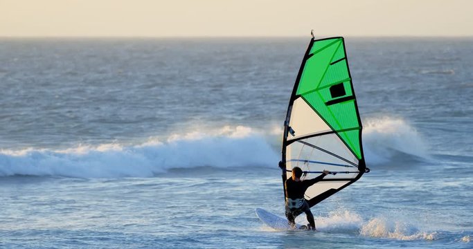 Male surfer windsurfing in the beach 4k