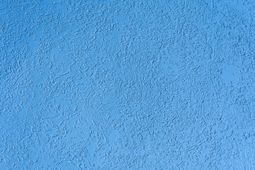 texture of the surface of the wall covered with decorative plaster of the woodworm type