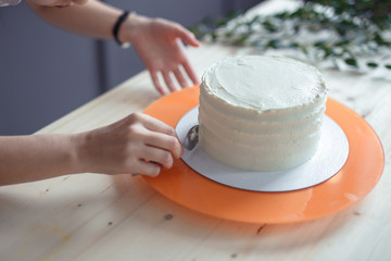 confectioner in a white apron on a dark background with a cake