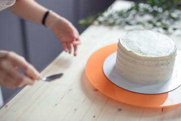 confectioner in a white apron on a dark background with a cake