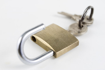 Brass padlock on a white table. Accessories for locking and securing against burglary.