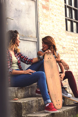 Skate girls sitting in the street hanging out