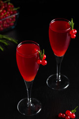 Two glasses redcurrant wine drink juice decorated with rosemary berries