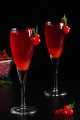 Two glasses redcurrant wine drink juice decorated with rosemary berries