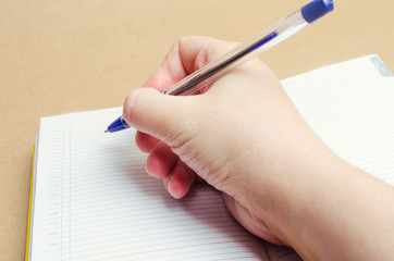 a female hand writes in a notebook and makes notes, plans for the day, shopping list, close-up, businessman makes notes on the calendar, concept school and education
