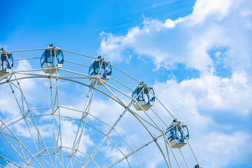 Ferris wheel on cloudy sky background