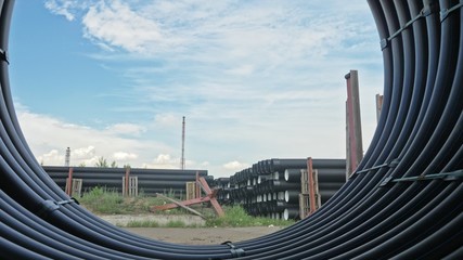 Obraz na płótnie Canvas Warehouse of finished plastic pipes industrial outdoors storage site. Manufacture of plastic water pipes factory. Process of making plastic tubes on the machine tool with the use of water and air