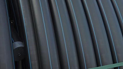 Fototapeta premium Warehouse of finished plastic pipes industrial outdoors storage site. Manufacture of plastic water pipes factory. Process of making plastic tubes on the machine tool with the use of water and air