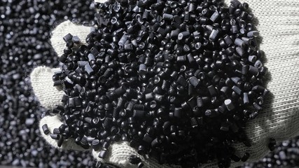 Plastic black gray granulated crumb. Manufacture of plastic water pipes of the factory. Process of making plastic tubes on the machine tool with the use of water and air pressure.