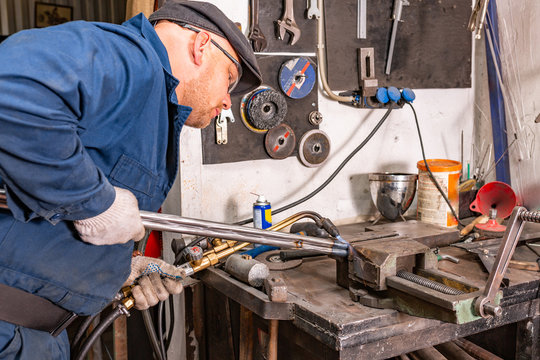The young man, is going to cut a piece of metal autogenous welding.