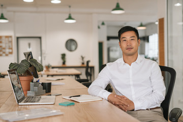 Confident Asian businessman working at his office desk