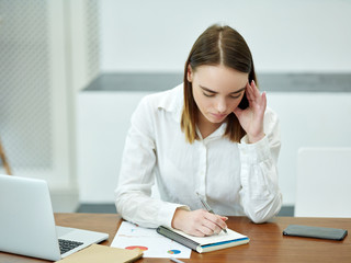 Intelligent woman preparing homework in library