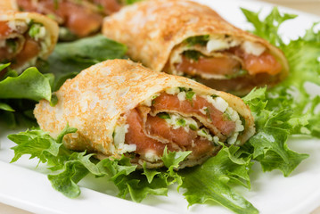 Roll pancakes with red fish and herb cream cheese.