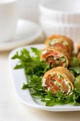 Roll pancakes with red fish and herb cream cheese.