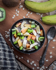 Breakfast with oatmeal porridge with fruits. Oatmeal with kiwi, peach and banana. Healthy breakfast concept. Top view