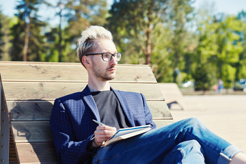 Obraz premium Man with notebook sitting on beach chair
