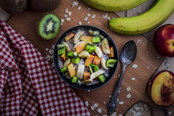 Breakfast with oatmeal porridge with fruits. Oatmeal with kiwi, peach and banana. Healthy breakfast concept. Top view