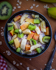 Breakfast with oatmeal porridge with fruits. Oatmeal with kiwi, peach and banana. Healthy breakfast concept. Top view