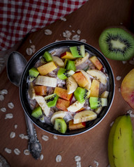 Breakfast with oatmeal porridge with fruits. Oatmeal with kiwi, peach and banana. Healthy breakfast concept. Top view