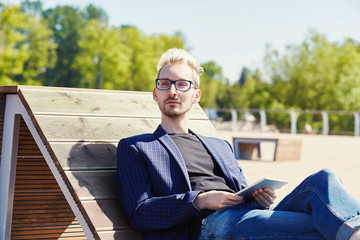 Fototapeta premium Man with tablet sitting on beach chair