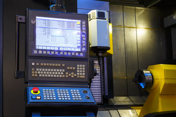modern CNC panel on the background of the open space of the machine, yellow component on a black background