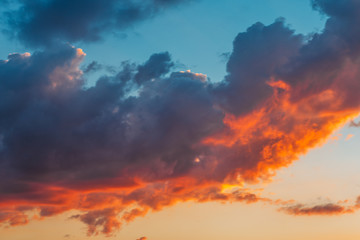Fototapeta na wymiar Colorful red and orange fluffy clouds at blue sky in sunset time, beautiful nature cloudscape