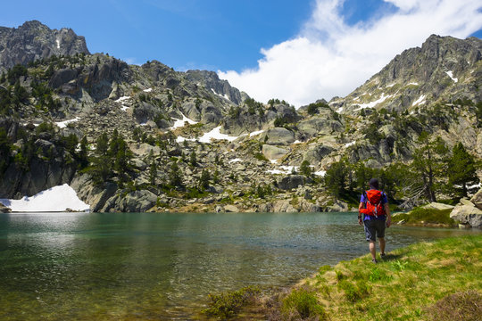Man walking by a lake in the national park of Aiguestortes and lake San Mauricio