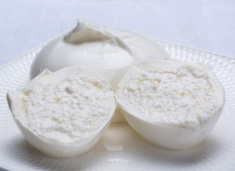 Fototapeta na wymiar Fresh soft white burrata, ball buttery cheese, made from a mix of mozzarella and ricotta cream, original from Apulia region, Italy, very popular soft cheese in USA
