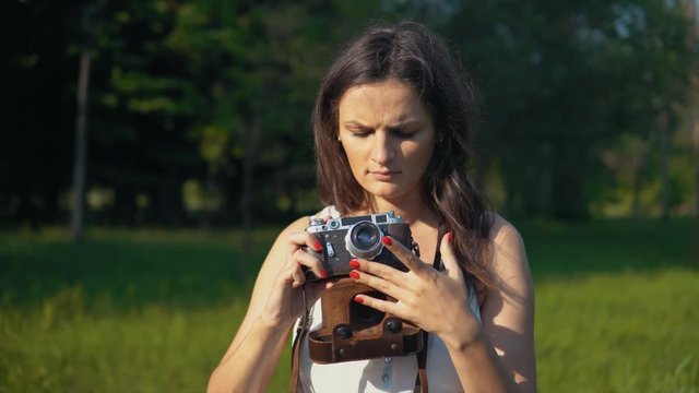 Young woman photographer taking pictures and photos with camera outdoors.