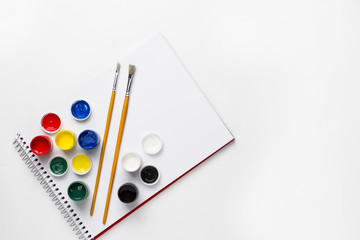 Drawing notebook, gouache paints, on white surface