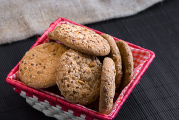 Savory cookies sprinkled with sesame seeds, sunflower on table and burlap background