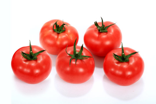 Pomidor czerwony, malinowy z szypółkami na białym tle.