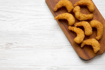 Fried shrimps tempura on wooden board on white wooden background, top view. Flat lay, overhead, from above. Copy space.
