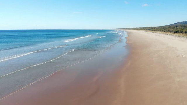 Deserted sandy beach Australia aerial ocean waves breaking on beach