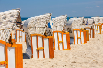 Fototapeta na wymiar Sandy beach and traditional wicker beach baskets at sunny day