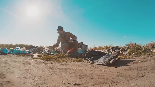 dirty homeless man at the dump slow motion video. homeless roofless person lifestyle looking for food in a dump. refugee homeless illegal immigration poverty concept