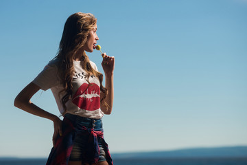 Beautiful girl sucks Lollipop in summer outdoors
