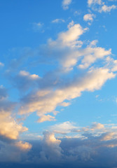 Naklejka na ściany i meble A blue sky with cumulus clouds at sunset ..