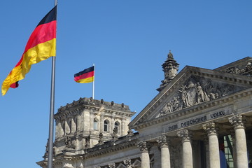 Exterior view of the historic building of Reichstag with a fluttering German flag