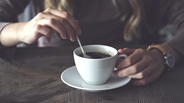 Female hands stirring coffee
