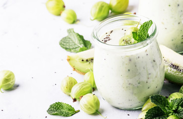 Smoothies from gooseberry, kiwi and yogurt with chia seeds, gray background, selective focus