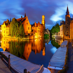 Scenic cityscape with a medieval fairytale town and tower Belfort from the quay Rosary, Rozenhoedkaai, at night in Bruges, Belgium