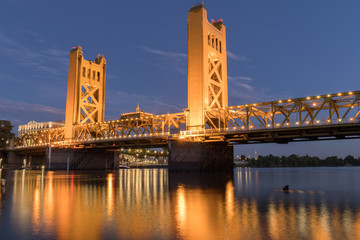 Tower Bridge and lights reflected on the Sacramento River. Sacramento and Yolo Counties,...