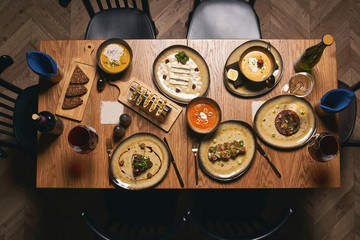 Table with food, top view. Different food cooked on the grill on a wooden table at restaurant. 