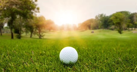 Foto op Plexiglas Golf ball on blurred beautiful green grass with sunlight in morning time. Sport and recreation playground for golf club concept. © Nischaporn