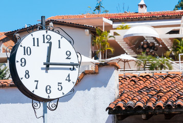 Clock, 12:15 p.m. in front of terracotta roofs and white walls/vacation.