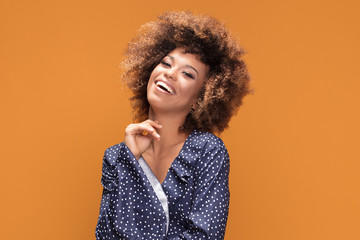 Happy african american lady smiling on yellow background.